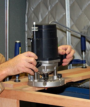 A router being used to cut a rebate into a timber component.